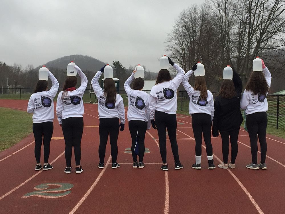  Brewster High School Girls stand with jugs of water on their heads at the first walk in 2019